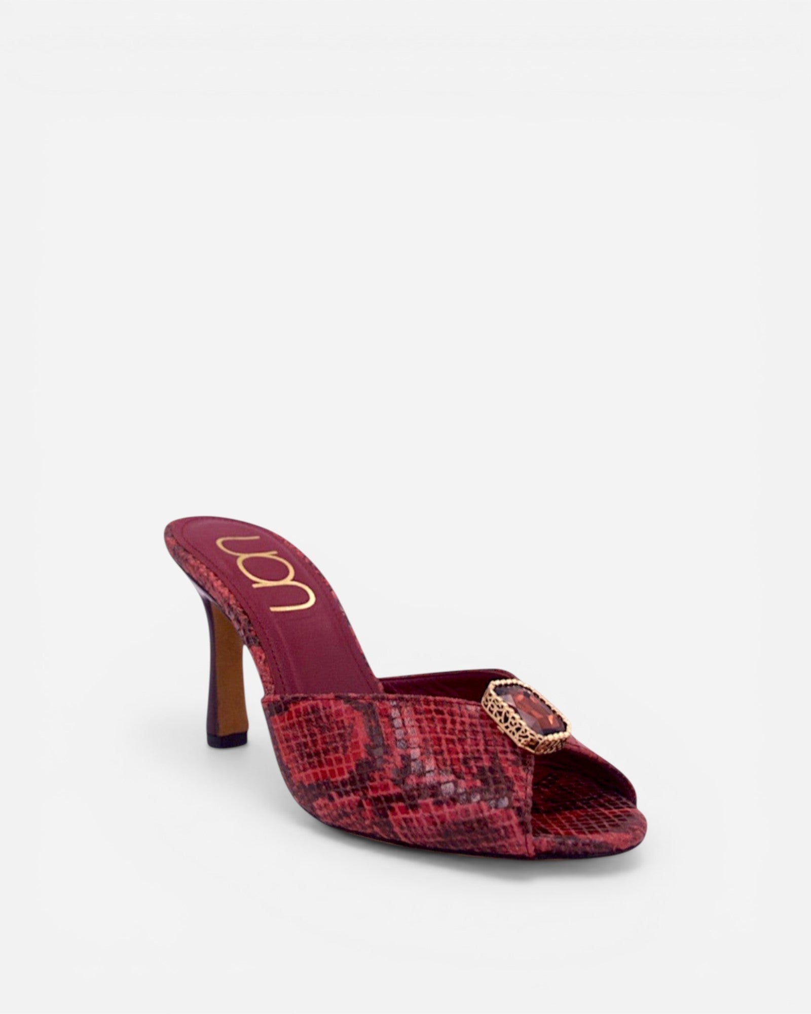 NOU red snakeskin leather mule heels with ruby gemstone accent and gold logo.