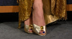 NOU The Addison Mule gold metallic peep-toe mules with a jeweled embellishment.