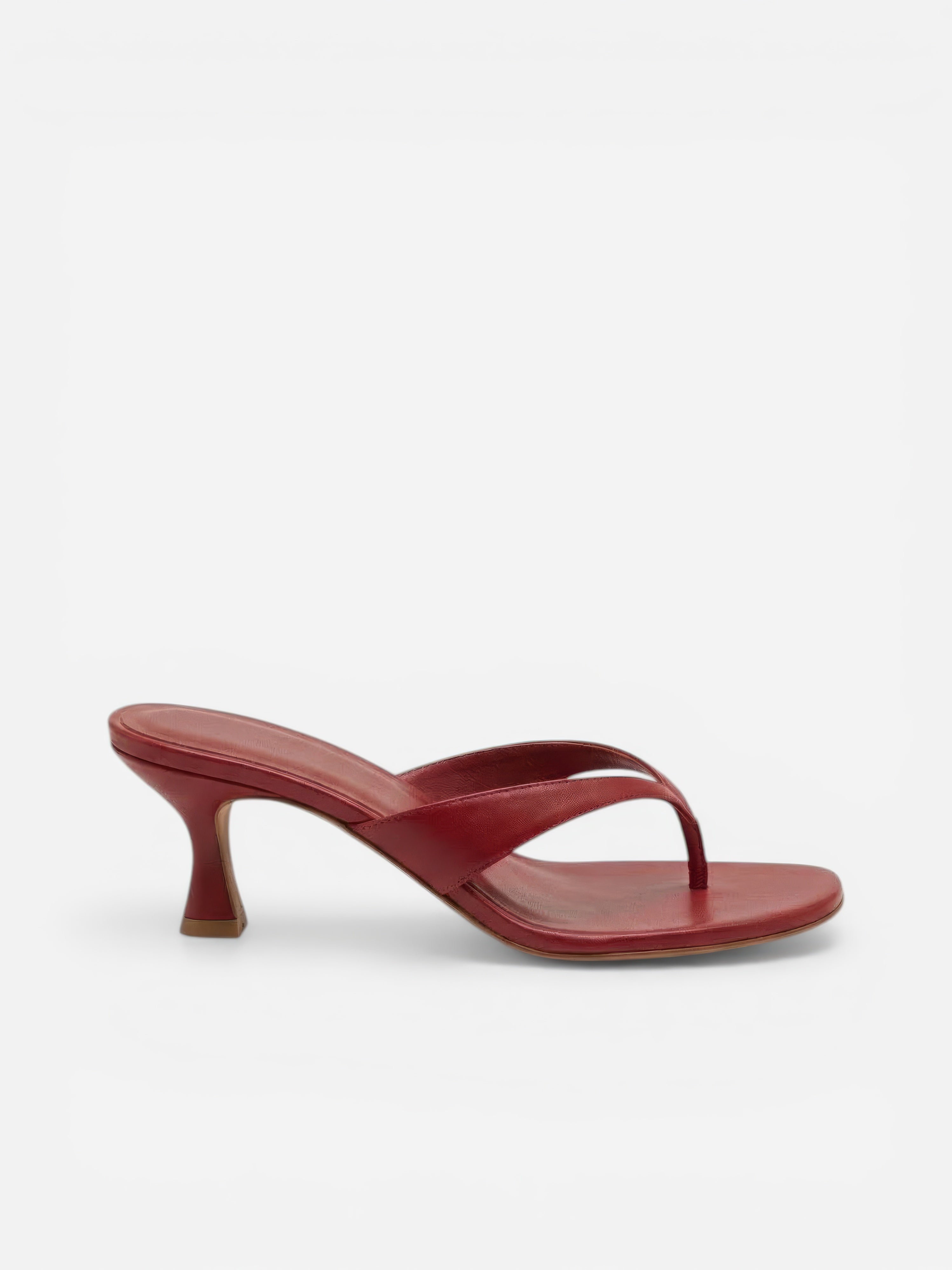 Red sandal with a thin strap on a white background