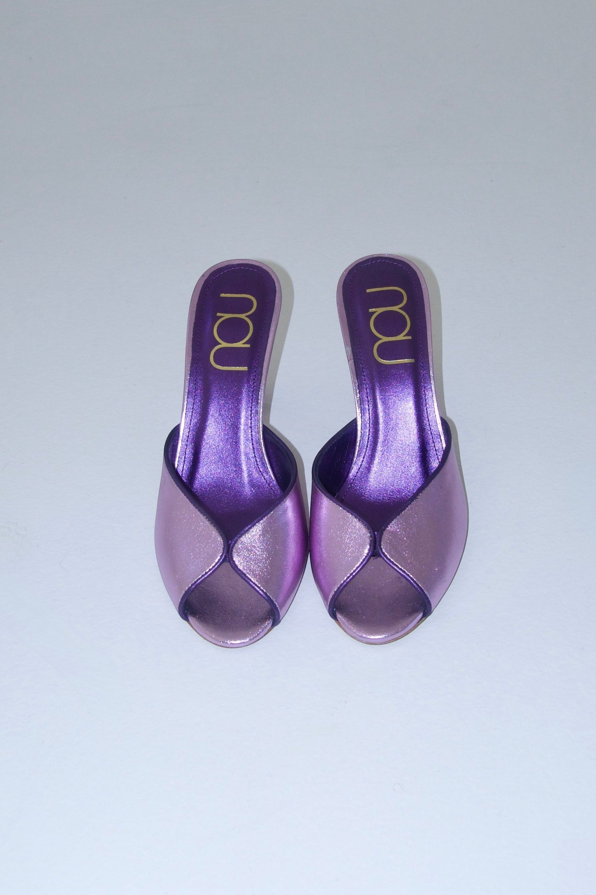 NOU ultraviolet metallic purple mule heels with peep toe and gold logo detail. Limited edition collector's piece.
