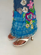 Blue floral embroidered dress with white high-heeled sandals on a plain background