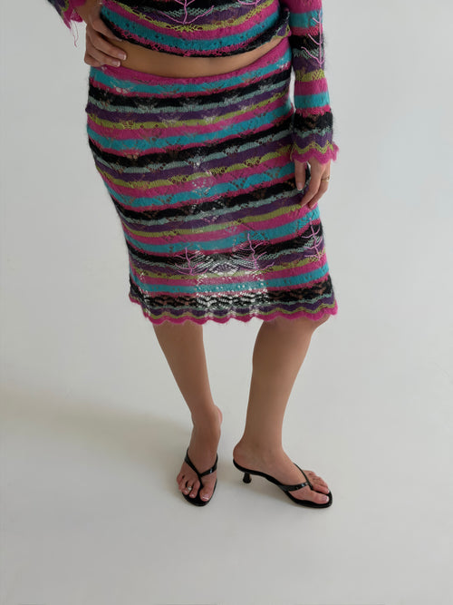 Person wearing a colorful striped dress on a white background