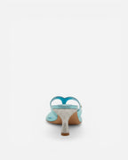 High-heeled shoe with blue strap and glittery sole on a white background