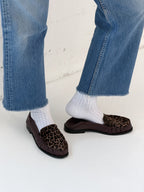 NOU The Driver loafers in burgundy leather with leopard print ponyhair, worn with white socks and cropped blue jeans.