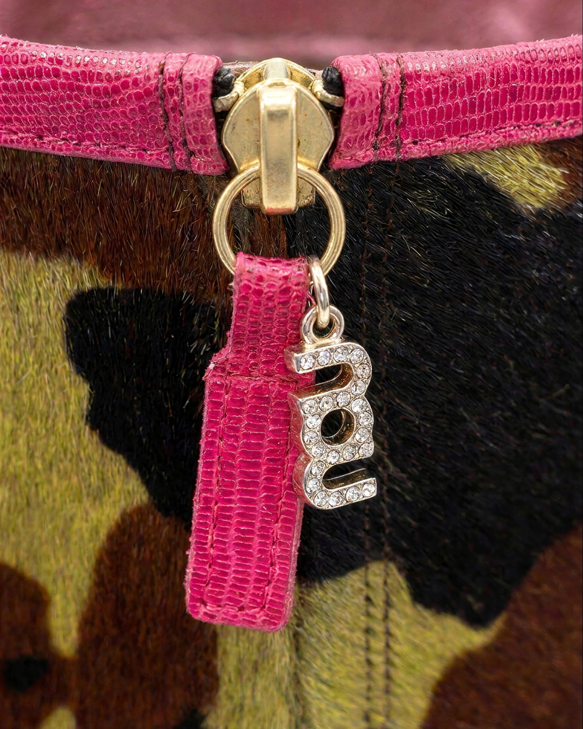 NOU The Boot featuring Undercover Lover camo ponyhair, metallic burgundy trim, and a rhinestone nou logo zipper pull.