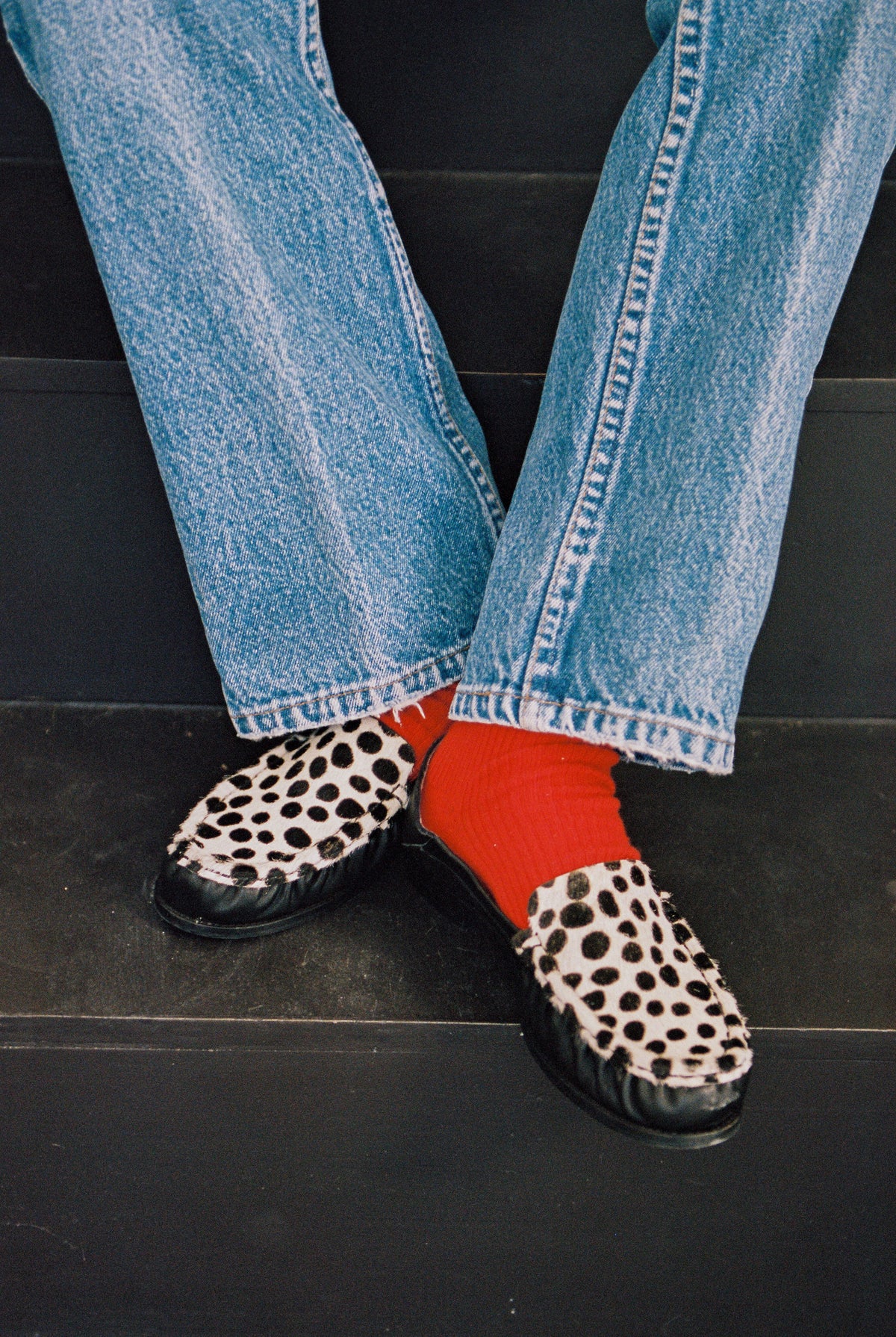 NOU The Driver black leather loafer with Dalmatian print ponyhair and gold interior lining in a red sock on model