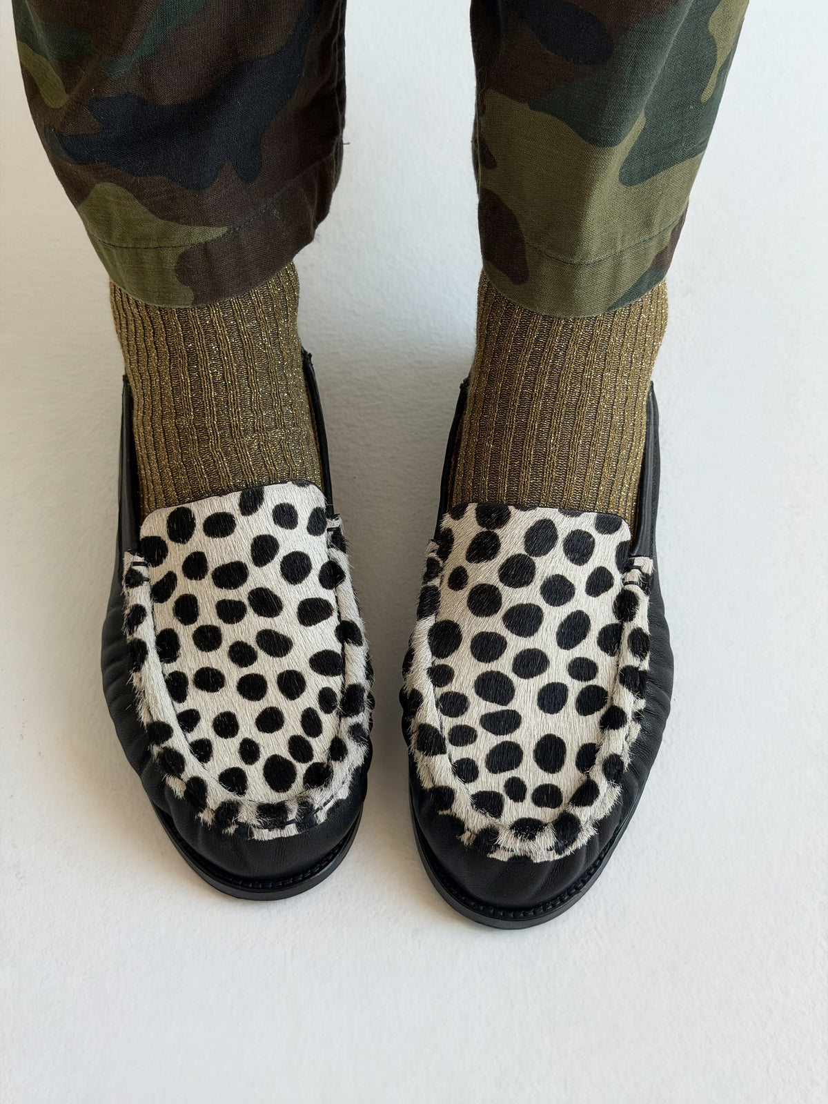 NOU The Driver black leather loafer with Dalmatian print ponyhair and gold interior lining in a green sock on model