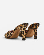 NOU leopard print ponyhair mule heels with a red trim and square toe.
