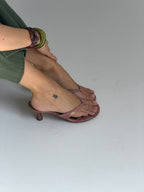 NOU The Kitty petal pink snakeskin kitten heel sandal with gold logo detail and metallic green insole on foot
