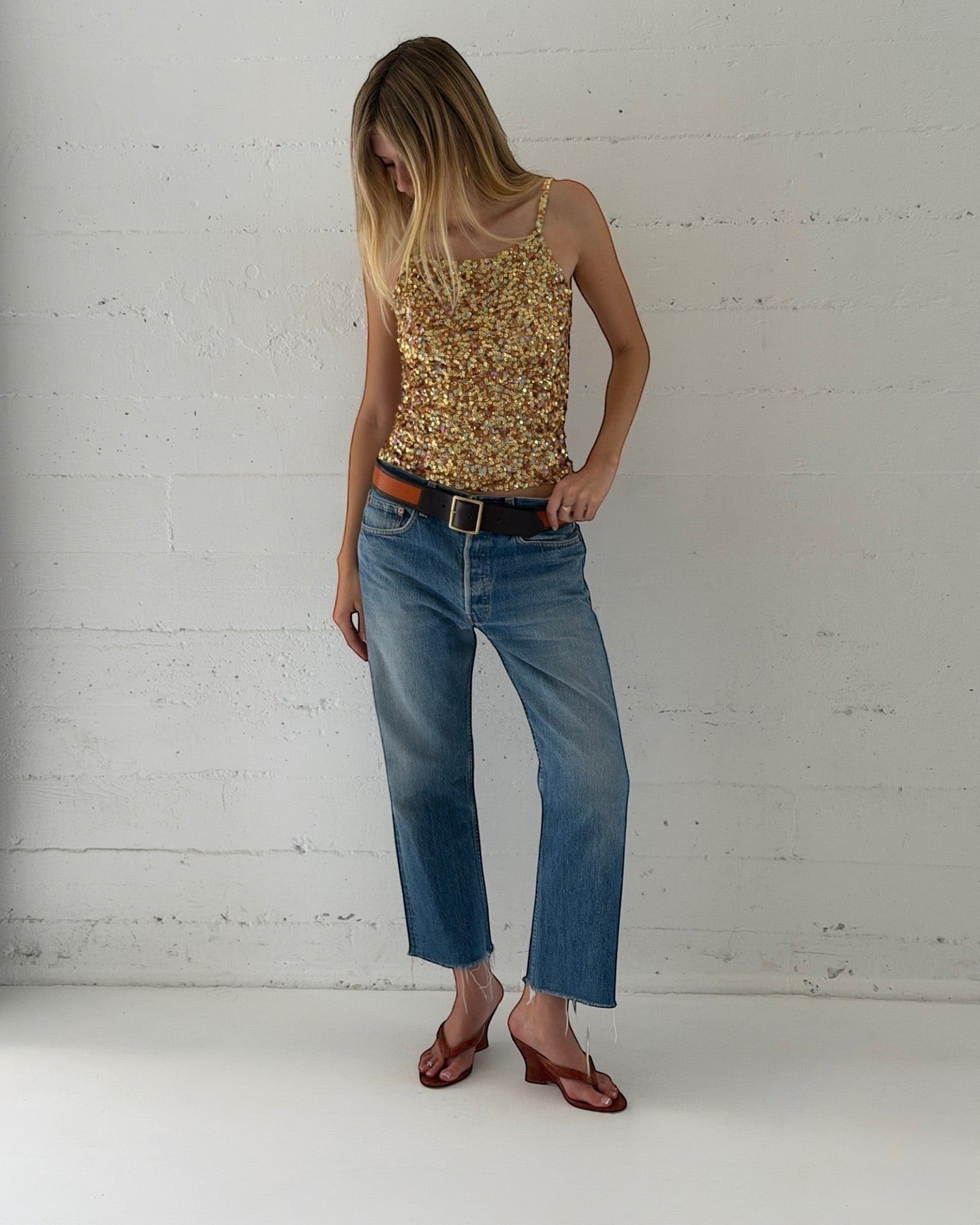Model wearing NOU The Puff Wedge in blood orange snakeskin with a 3-inch sculptural heel and marigold insole.