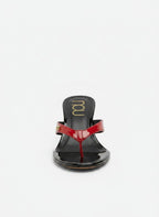 NOU The Puff Wedge patent flip-flop sandals in red and black with a 3" heel and gold logo detail.