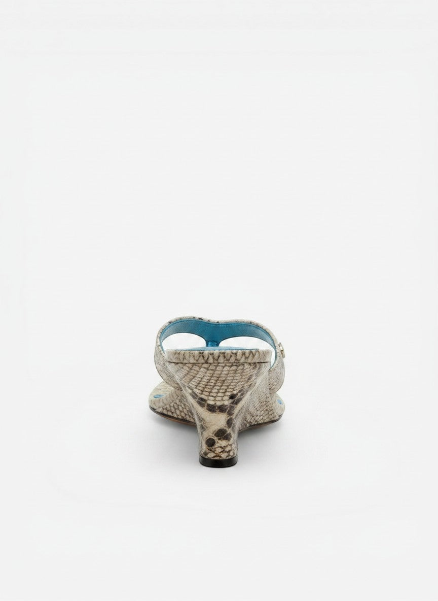 NOU The Puff Wedge sandals in icy silver snakeskin with a 3" sculptural wedge heel and plush straps. Blue insole.