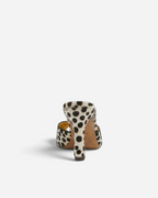 NOU The Mule in dalmatian print ponyhair with a metallic gold insole, shown from a rear heel view.